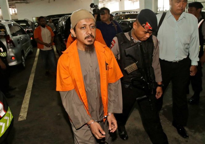 Nghi phạm Abdul Hakim Munabari (áo vàng) bị cảnh sát dẫn giải tới tòa án ở Jakarta - Ảnh: AP