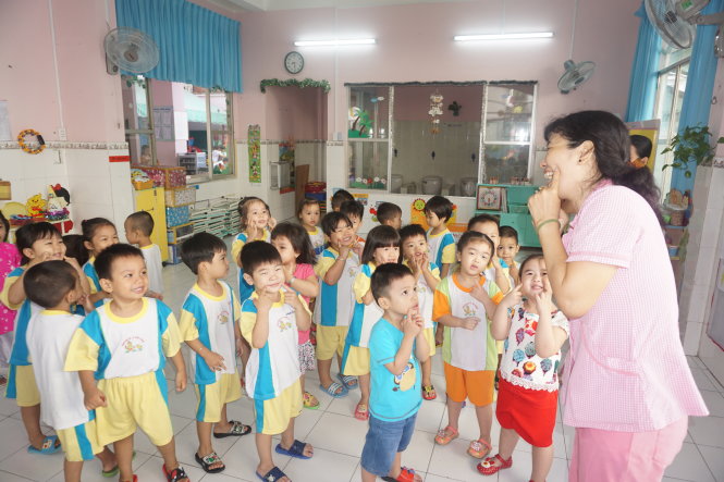 Học sinh lớp mầm Trường mầm non 7B, Q.Bình Thạnh (TP.HCM) vui vẻ chơi trò chơi với cô giáo sau 16 ngày nghỉ tết - Ảnh: H.HG.