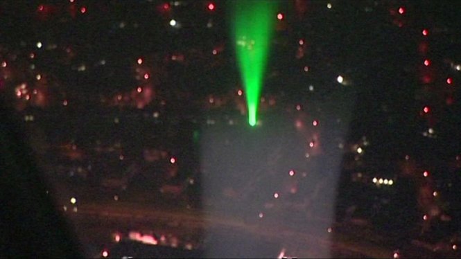 Sử dụng bút laser buổi đêm chiếu vào máy bay gây nguy hiểm rất lớn với an toàn bay - Ảnh: BBC