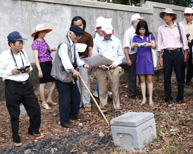 Nhà nghiên cứu Nguyễn Đắc Xuân giới thiệu với GS Phan Huy Lê (thứ tư từ trái) và giới sử học về một hiện vật đá với hoa văn rất đẹp, phát hiện tại cồn Bông Sứ. Tại đây có khá nhiều hiện vật như thế  - Ảnh: Minh Tự