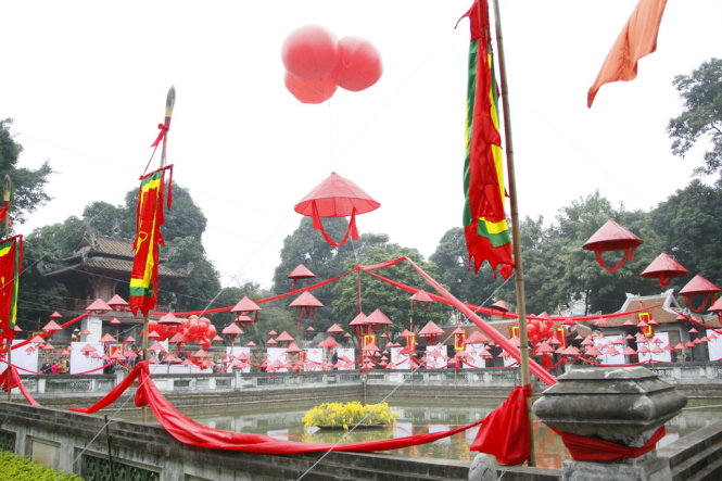 Hồ Thiên Quang Tỉnh đỏ rực với cờ thần, bóng lớn và nón bài thơ. ảnh Đức Triết