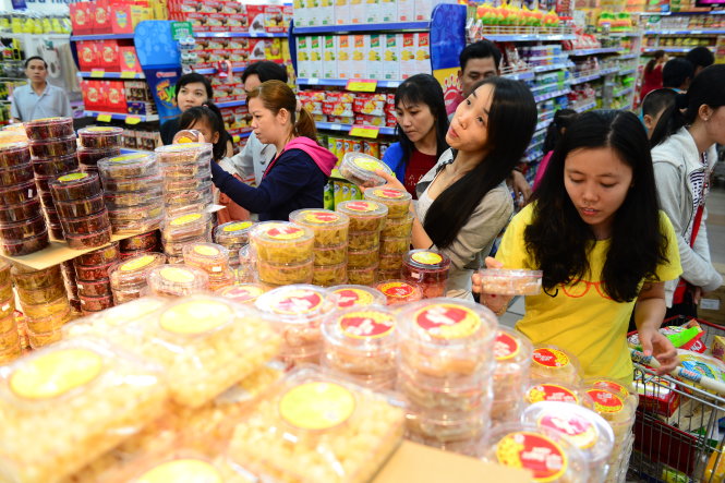 Người dân chọn mua bánh kẹo cho ngày tết tại siêu thị Co.op Mart trên đường Nguyễn Văn Linh, Q.7, TP.HCM tối 2-2 - Ảnh: Quang Định