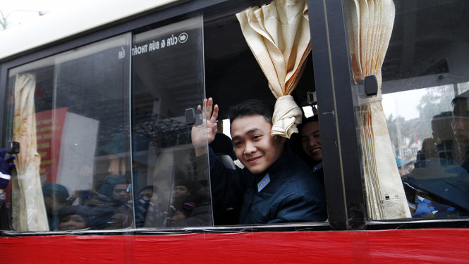 Một tân binh của quận Ba Đình sau khi lên xe vẫn tươi cười tạm biệt với gia đình, bạn bè của mình - Ảnh: Nam Trần
