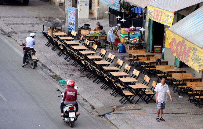 Đầu giờ chiều các quán nhậu trên đường Phạm Văn Đồng bắt đầu bày bàn ghế ra tận sát bờ đường để chuẩn bị bán cho khách vào buổi tối - Ảnh: Duyên Phan