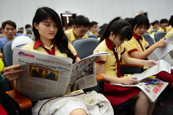 Học sinh Trường THPT Thành Nhân TP.HCM đọc báo Tuổi Trẻ được phát miễn phí tại ngày hội - Ảnh: Quang Định