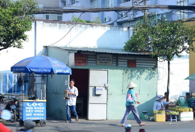 Trên đường Nguyễn Thái Sơn ( P.7, Q.Gò Vấp, TP.HCM) một chốt bảo vệ dân phố được đặt ngay trên vỉa hè, xung quanh là người dân ngồi buôn bán. Trong hình, một người đàn ông lấy hàng ra từ chốt Bảo vệ - Ảnh: Duyên Phan