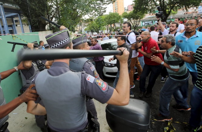 Người ủng hộ ông Lula đối đầu cảnh sát trước nhà ông khi hay tin ông bị bắt. Cựu tổng thống Lula (ảnh nhỏ) khóc khi nói chuyện với người ủng hộ ở Sao Paulo tối 4-3 - Ảnh: Reuters
