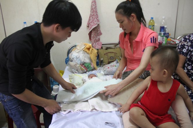 Gia đình chị Nga và con trai được sinh ra trên máy bay tại Bệnh viện Phụ sản - nhi Đà Nẵng sáng 5-3 - Ảnh: Đoàn Cường