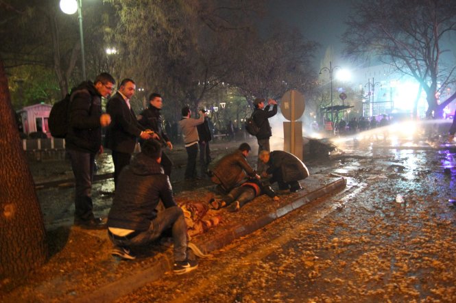 Mọi người đang trợ giúp một người bị thương gần hiện trường vụ nổ ở Ankara, Thổ Nhĩ Kỳ - Ảnh: Reuters