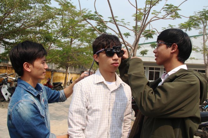Ba thành viên của nhóm sáng chế (từ trái qua: Nguyễn Mạnh Tuấn, Lê Nhật Hưng và Nguyễn Trần Viết Chương) thử nghiệm kính đa năng dành cho người khiếm thị - Ảnh: P.Thành