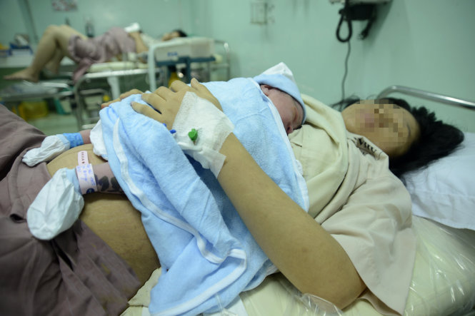 Trẻ sau khi sinh sẽ được đánh dấu bằng cách đeo vòng có ghi tên, giờ sinh lên chân và không rời mẹ để tránh nhầm lẫn tại Bệnh viện Hùng Vương (TP.HCM) - Ảnh: Duyên Phan