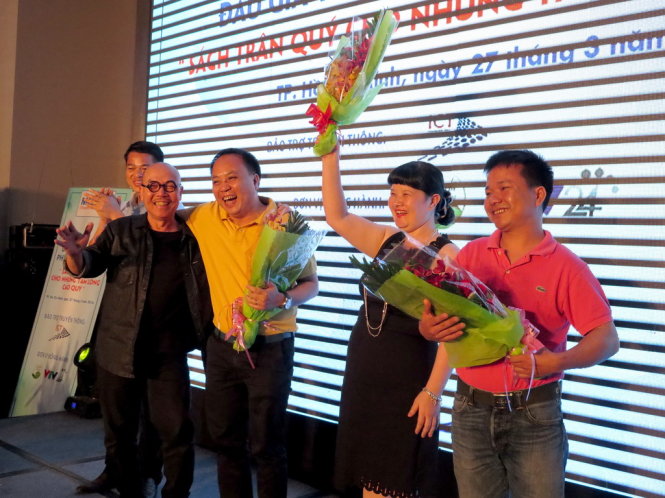 Họa sĩ Thành Chương (áo đen, bìa trái) lên tặng hoa cho ba vị khách hàng thắng phiên đấu giá. Ảnh: L.Điền
