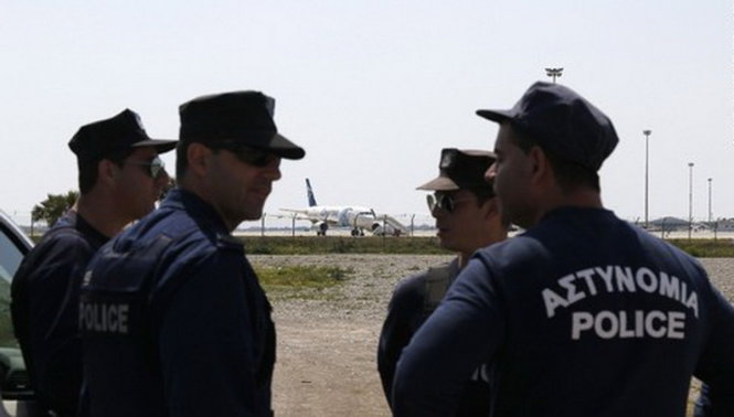Cảnh sát Cyprus được nhìn thấy đứng gần chiếc máy bay bị không tặc - Ảnh: CNN