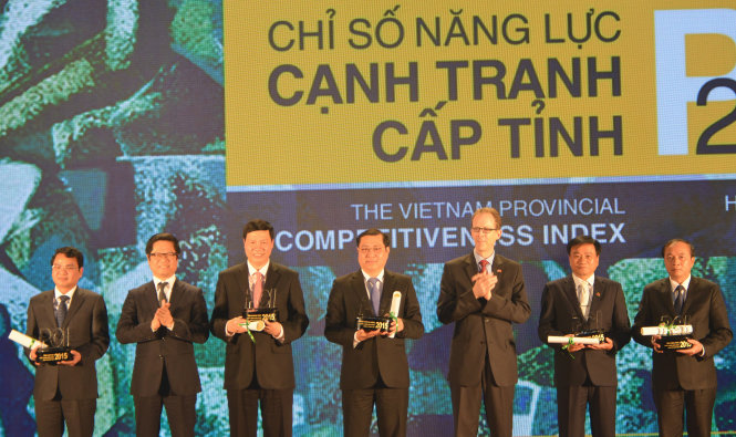 Chủ tịch VCCI Vũ Tiến Lộc (thứ hai từ trái sang) và giám đốc USAID Việt Nam Joakim Parker (thứ ba từ phải sang) chụp hình với lãnh đạo 5 tỉnh thành đạt chỉ số PCI 2015 cao nhất - Ảnh: Quỳnh Trung