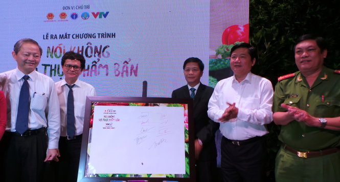 Ông Đinh La Thăng (áo trắng bìa phải) cùng các ông Lê Văn Khoa (ngoài cùng bìa trái - Phó chủ tịch UBND TP.HCM), ông Trần Bình Minh (thứ hai bìa trái - UV TƯ Đảng - Tổng giám đốc Đài truyền hình VN) ký vào cam kết đồng hành cùng chương trình Nói không với thực phẩm bẩn của VTV24. Ảnh: C.K