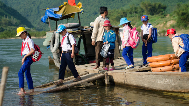 Các em học sinh thôn 1 và thôn 2 xã Hiệp Hòa vẫn hằng ngày đi học trên con đò cũ nát - Ảnh: Tấn Lực