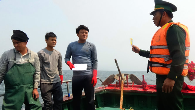 BĐBP Quảng Bình cảnh cáo ngư dân trên một tàu cá của Trung Quốc vi phạm lãnh hải VN trước khi xua dduoir ra khỏi vùng biển VN - Ảnh: Lam Giang