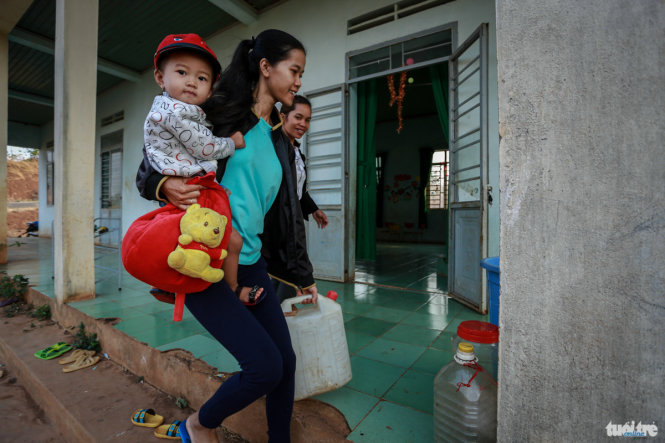 Mỗi buổi sáng, người dân ở buôn Ea Kring vừa bồng bế con đến trường, vừa xách theo một can nước 5 lít để phục vụ nhu cầu sinh hoạt của con họ tại trường
