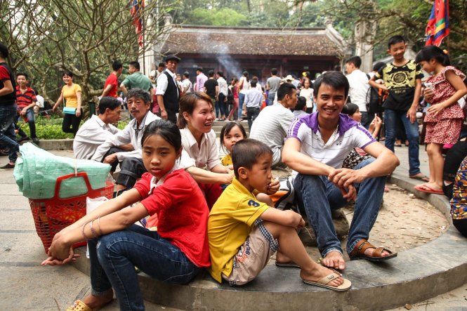Một gia đình nghỉ chân tại đền Trung, do thời tiết khá oi bức nên việc di chuyển của người dân gặp nhiều khó khăn đặc biệt là những gia đình có người già và trẻ nhỏ - Ảnh: Nguyễn Khánh