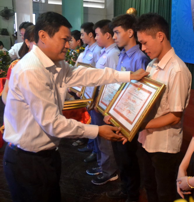 Ông Huỳnh Cách Mạng, phó trưởng Ban tổ chức Thành ủy TP.HCM, trao bằng khen của UBND TP cho các thí sinh đoạt giải nhất kỳ thi Tay nghề trẻ TP -Ảnh: Q.PHƯƠNG