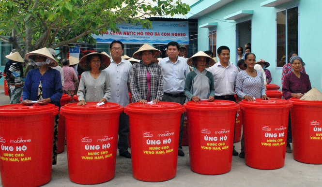 Đại diện lãnh đạo Mobiphone cùng báo Tuổi Trẻ tặng thùng nhựa cho bà con xã Nam Thái A, huyện An Biên - Ảnh: K.Nam.