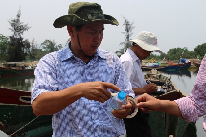 Mẫu nước được lấy (trong chai nhựa) sẽ được gửi đến các phòng thí nghiệm thuộc Bộ NN&PTNN và các cơ quan chức năng liên quan để phân tích, kiểm tra nhằm xác định nguyên nhân cá chết dọc bờ biển miền Trung - Ảnh: Nhật Linh