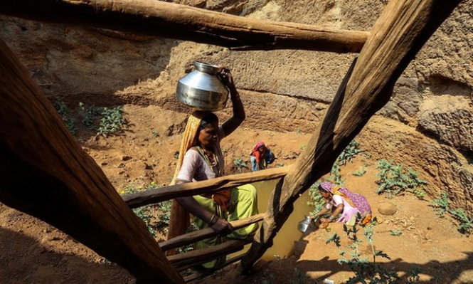 Người dân Ấn Độ phải tìm nước ở những ao tù động gần như cạn khô vì hạn hán - Ảnh: theguardian.com