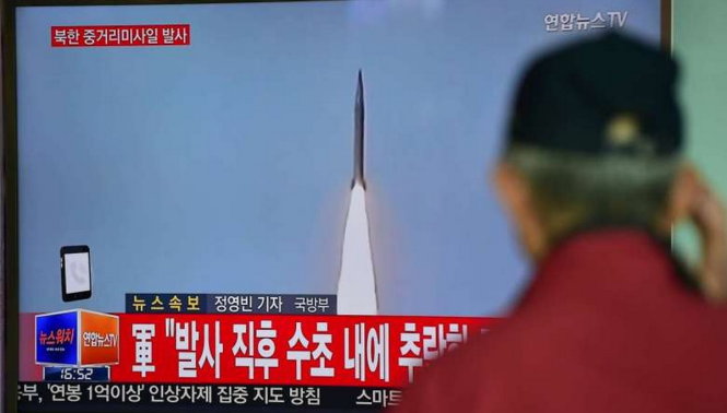 Người dân Hàn Quốc xem bản tin Triều Tiên phóng tên lửa trên đài truyền hình Hàn Quốc ở nhà ga Seoul hôm 28-4 - Ảnh: AFP