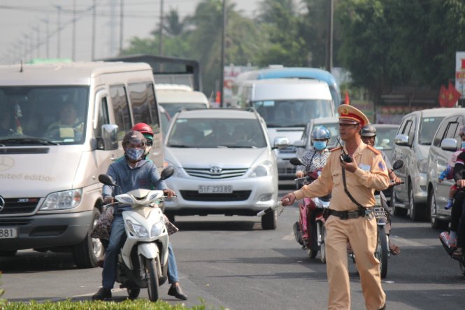 Cảnh sát giao thông mướt mồ hôi điều tiết giao thông tại ngã tư Đồng Tâm, Tiền Giang sáng 30-4 - Ảnh: Mậu Trường