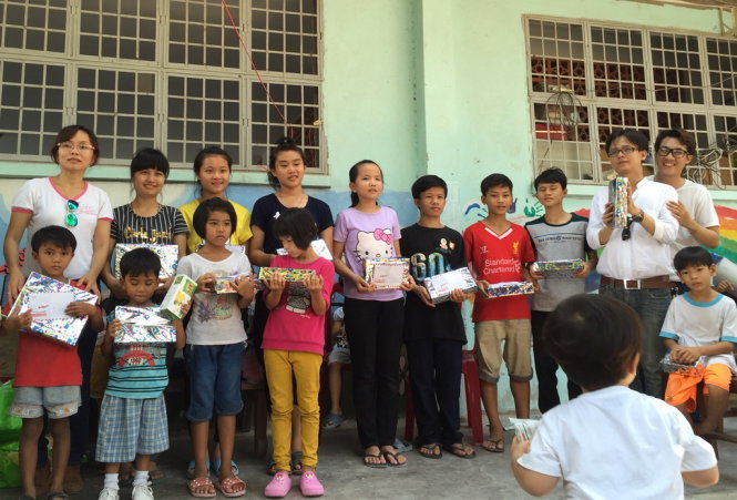Các em nhỏ ở Mái ấm nhận quà của SMS Band và nhóm thiện nguyện Chân Trời Việt - Ảnh: Quốc Huy