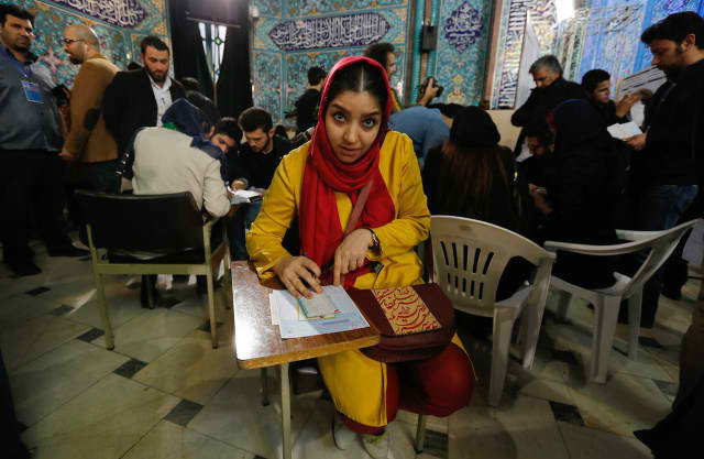 Một phụ nữ Iran điền thông tin vào lá phiếu của chị tại một điểm bỏ phiếu ở Tehran, Iran - Ảnh: EPA