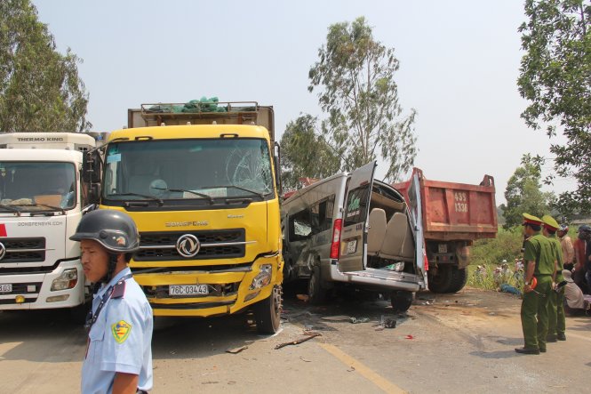 Hiện trường vụ tai nạn ở Quảng Ngãi, chiếc xe khách bẹp dúm nằm giữa hai xe tải - Ảnh: Trần Mai