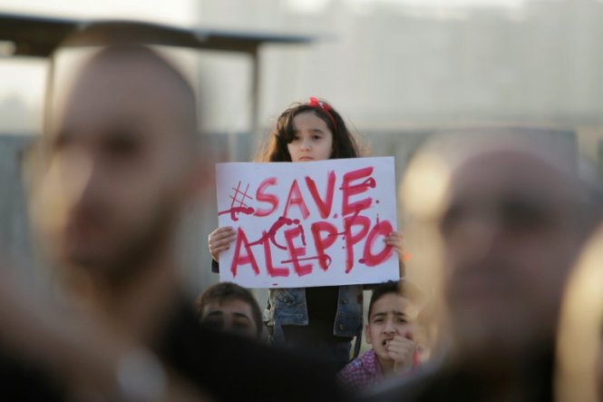 Một bé gái Syria cầm tấm biển ghi “Hãy cứu Aleppo” trong một cuộc tuần hành biểu thị tinh thần đoàn kết với người dân Aleppo tại thành phố cảng Tripoli của Lebanon ngày 1-5 - Ảnh: AFP