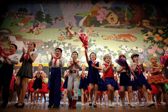 Các em nhỏ vẫy tay với người xem khi tấm màn sân khấu buông xuống vào cuối buổi biểu diễn tại Cung thiếu nhi Mangyongdae ở Bình Nhưỡng - Ảnh: Reuters