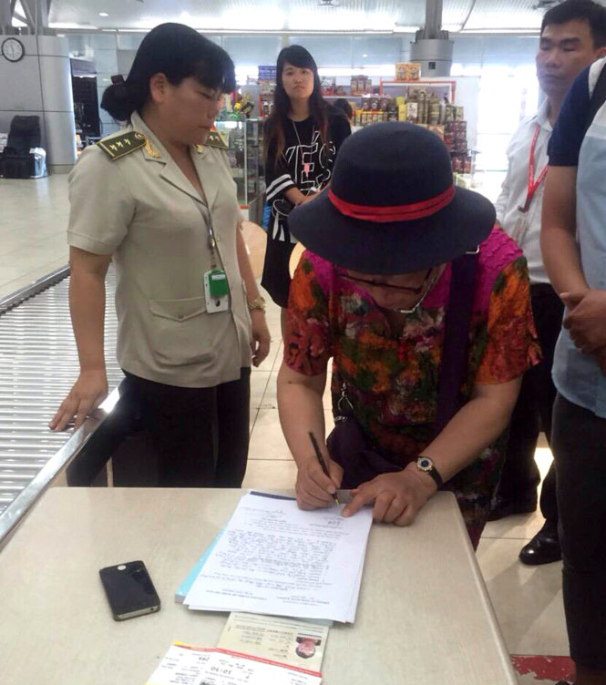 Bà Yan Fengge ký vào biên bản về hành vi trộm điện thoại di động của đồng hương đi cùng chuyến bay - Ảnh: An ninh hàng không Cam Ranh
