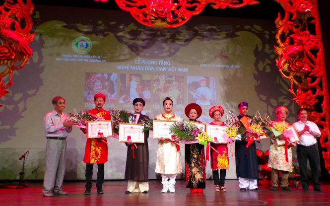 GS-TS Ngô Đức Thịnh (bìa trái) và TS Trần Hữu Sơn (bìa phải) trao tặng danh hiệu nghệ nhân dân gian cho các thanh đồng cung văn. Ảnh: C.K