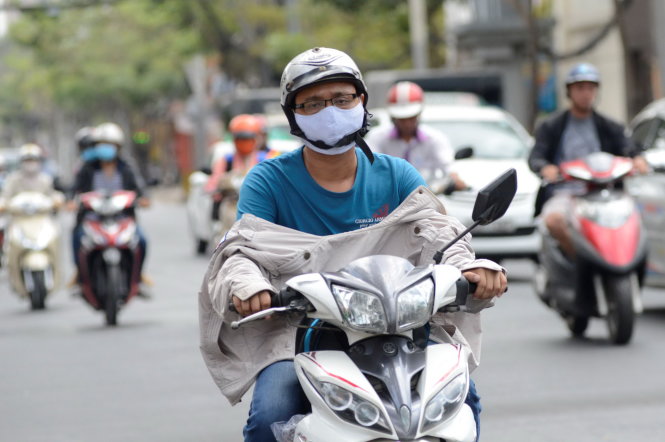 Một người đàn ông chạy xe trên đường 3 Tháng 2 (Q.10, TP.HCM) không chịu nổi nắng nóng của Sài Gòn, phải mặc ngược áo khoác lại để tránh ánh nắng chiếu thẳng từ phía trước - Ảnh: Duyên Phan