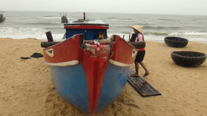 Một tàu cá bị hư hỏng nặng, được người dân giúp kéo lên bờ - Ảnh: Quốc Nam