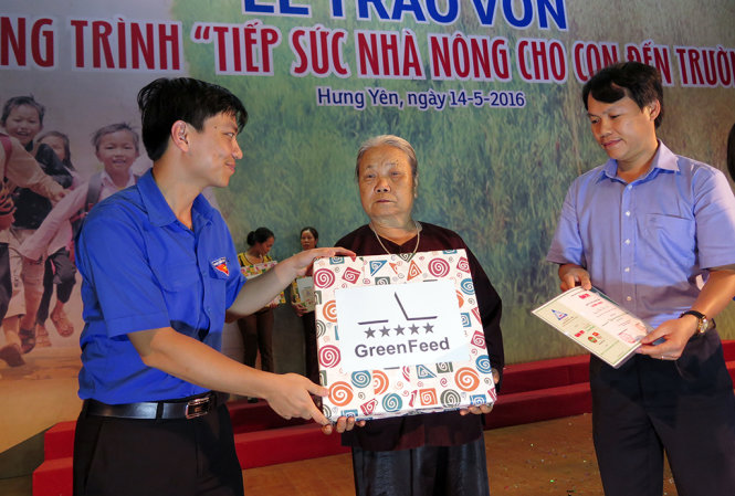 Ông Hồ Thanh Vinh (bìa phải) – phó trưởng Văn Phòng đại diện báo Tuổi Trẻ tại miền Bắc và đại điện Tỉnh đoàn trao quà cho hộ nông dân nghèo có con, cháu học giỏi - Ảnh: QUANG THẾ