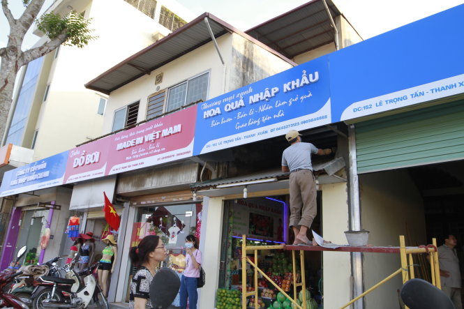 Lắp đặt biển hiệu “đồng phục” xanh đỏ trên phố Lê Trọng Tấn, Hà Nội - Ảnh: Nam Trần