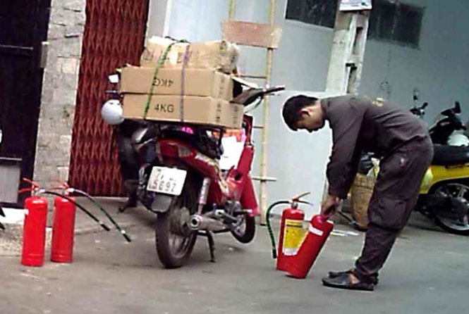 Trần Đình Tài xưng là “cán bộ” Cảnh sát PCCC TP.HCM đi giao bình chữa cháy cho một xưởng may trên đường Đồng Đen (P.10, Q.Tân Bình) - Ảnh: Hoàng Lộc