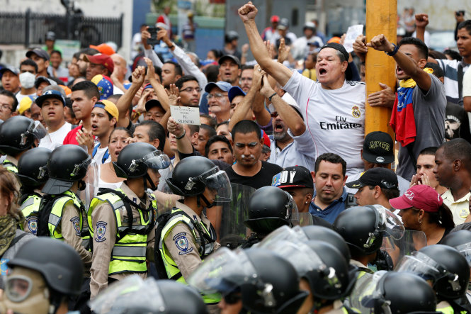 Người biểu tình đụng độ với cảnh sát ở Caracas ngày 18-5 - Ảnh: Reuters