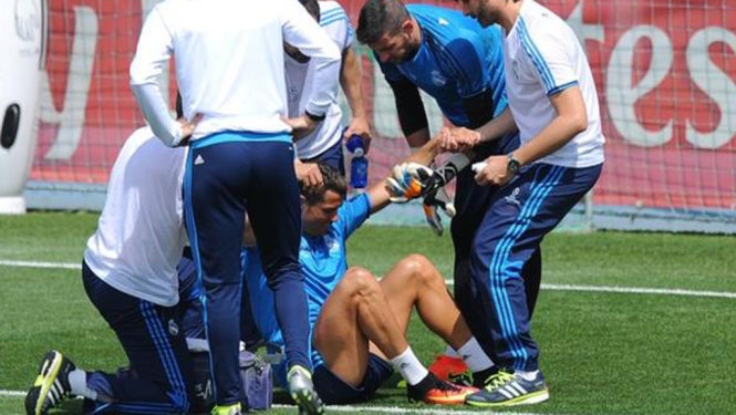 Các bác sĩ đỡ Ronaldo đứng dậy sau khi anh bị chấn thương. Ảnh: Getty Images