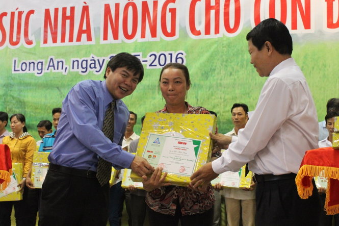 Ông Tăng Hữu Phong (trái), tổng biên tập báo Tuổi Trẻ trao quà cho một hộ dân - Ảnh: Đức Hiếu