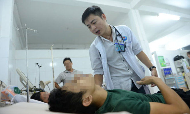 Bác sĩ Minh điều trị cho bệnh nhân tại khoa cấp cứu Bệnh viện Q.Gò Vấp - Ảnh: Hữu Khoa