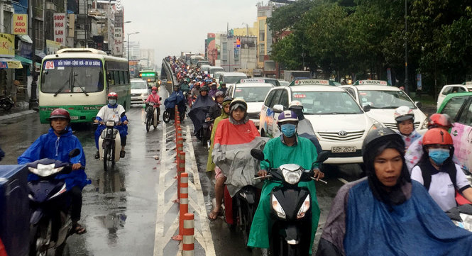 Xe cộ ùn ứ trên cầu vượt vì sự cố taxi rớt bánh xe - Ảnh: Ngọc Khải