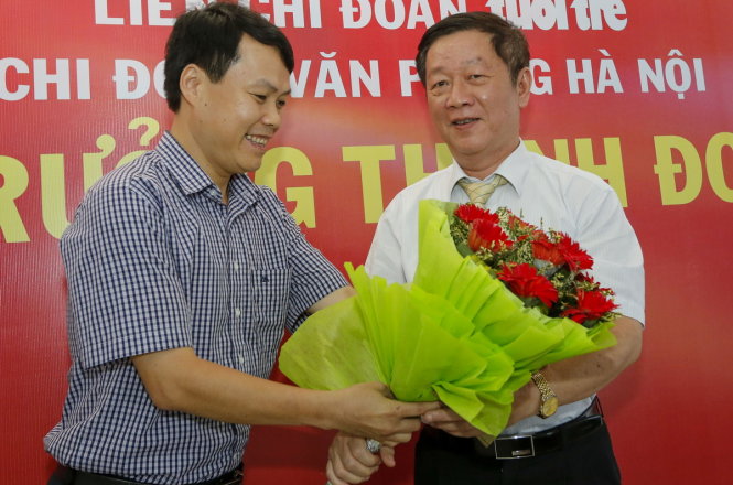 Đại diện Văn phòng báo Tuổi Trẻ tại Hà Nội tặng hoa cho khách mời, ông Phùng Đắc Lộc, TTK Hiệp hội bảo hiểm Việt Nam - ảnh VIỆT DŨNG