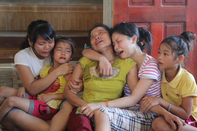 Bà Nguyễn Thị Mai (vợ ông Hậu) khóc ngất bên bốn cô con gái khi chờ đón thi thể ông Hậu - Ảnh: Doãn Hòa