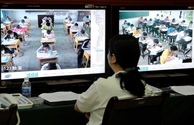 Nhân viên của trung tâm chỉ huy các kỳ thi của thành phố Trùng Khánh đang giám sát thí sinh tham dự kỳ thi tuyển sinh đại học - Ảnh: Reuters