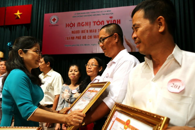 Bà Trần Thị Như Tố (giám đốc Trung tâm Hiến máu nhân đạo TP.HCM) trao bằng khen cho các cá nhân hiến máu tiêu biểu sáng 11-6 - Ảnh: NGỌC DƯƠNG